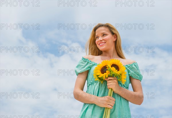 Woman holding sunflowers.