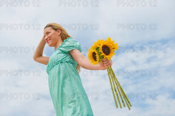 Woman holding sunflowers.