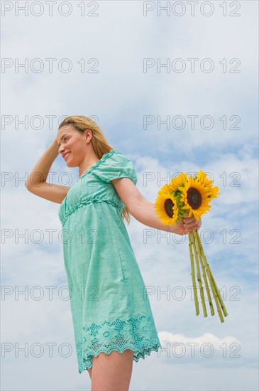 Woman holding sunflowers.