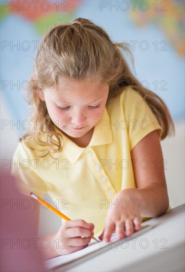 Girl (8-9) taking exam.