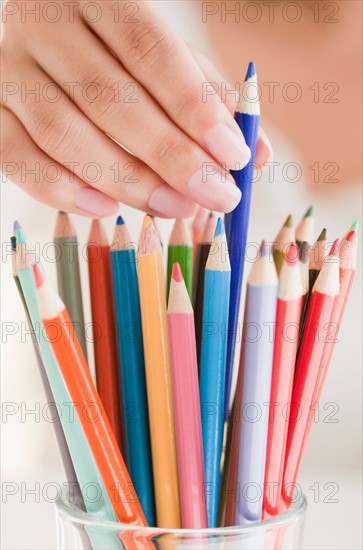 Close up of woman's hand picking colorful pencils. Photo : Jamie Grill