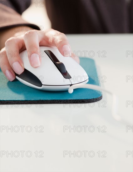 Close up of woman's hand using computer mouse. Photo: Jamie Grill