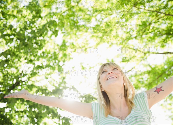 USA, New York, Williamsburg, Brooklyn, Portrait of smiling woman under green tree. Photo : Jamie Grill