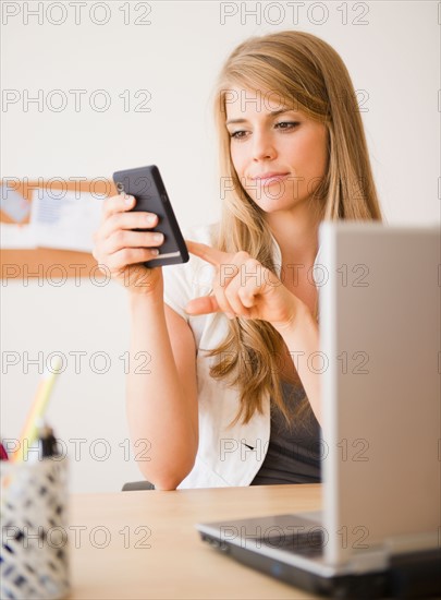 Businesswoman working at desk in office. Photo: Jamie Grill