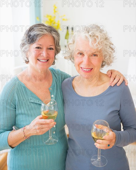 Two senior women holding wine glasses. Photo : Daniel Grill