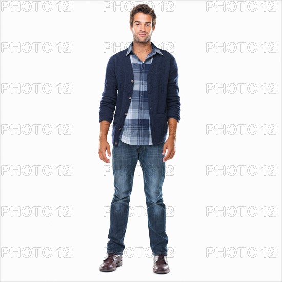 Studio shot of young confident man standing on white background and smiling. Photo : momentimages