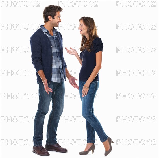 Studio shot of young couple smiling and talking. Photo : momentimages