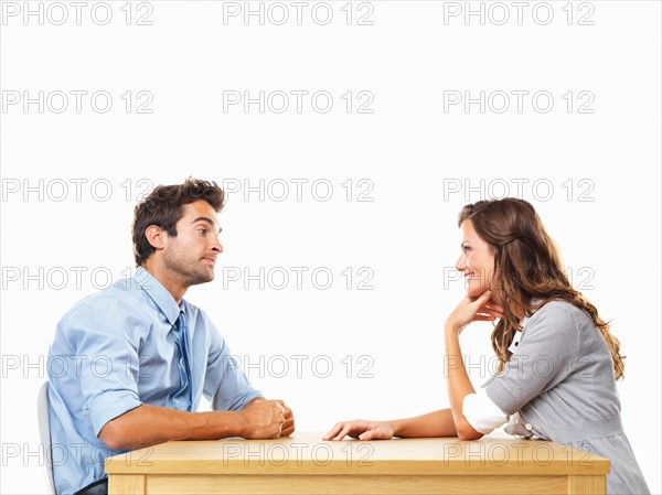 Uninterested business man and smiling business woman sitting at table for date. Photo : momentimages