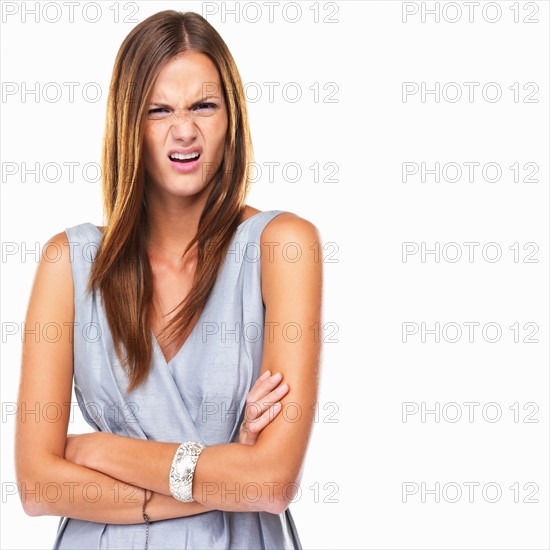 Portrait of young distressed woman standing with hands folded. Photo : momentimages