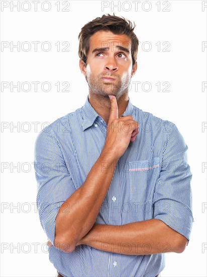 Thoughtful business man with finger on chin looking away. Photo : momentimages