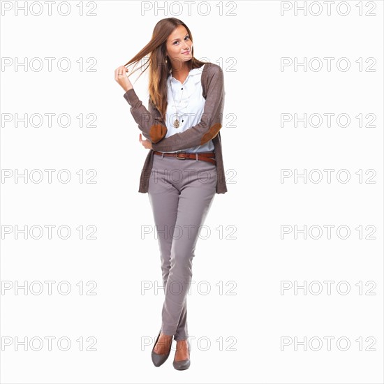 Studio shot of cute business woman playing with hair. Photo : momentimages