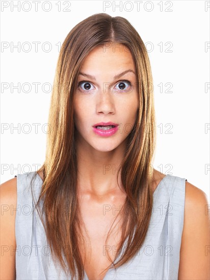 Studio portrait of young surprised woman staring on camera. Photo : momentimages