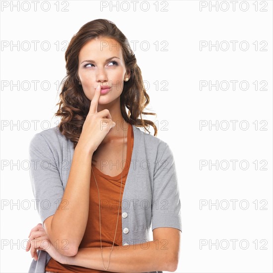 Studio portrait of woman with finger on lips. Photo : momentimages