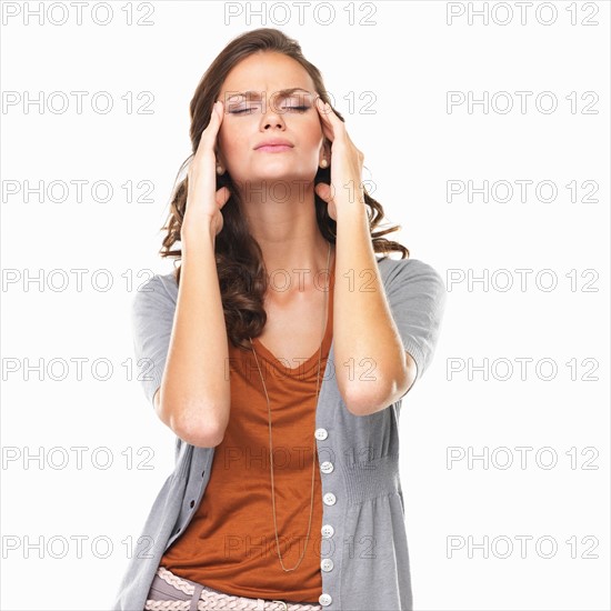 Studio portrait of with head in hands. Photo : momentimages