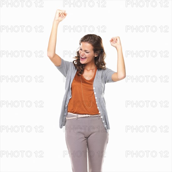 Studio portrait of excited young woman cheering. Photo: momentimages
