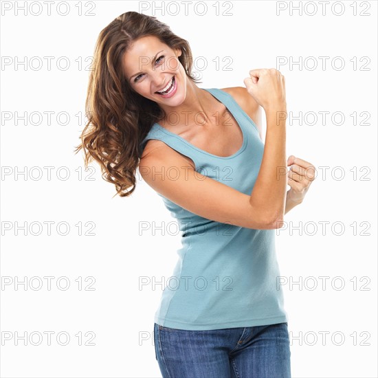 Studio portrait of attractive young woman with fists clenched. Photo : momentimages