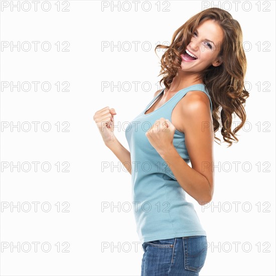 Studio portrait of attractive young woman with fists clenched. Photo: momentimages