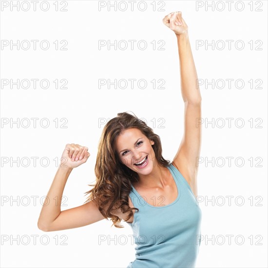 Studio portrait of beautiful woman with fists clenched in victory. Photo: momentimages