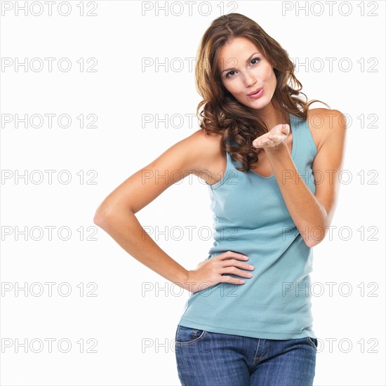 Studio portrait of cute young woman blowing kiss. Photo : momentimages