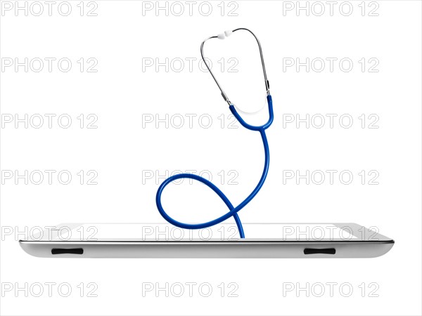 Studio shot of stethoscope coming out from digital tablet. Photo : David Arky