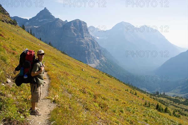 USA, Montana, Glacier National Park, Browns Pass, Mid adult hiker posing . Photo: Noah Clayton