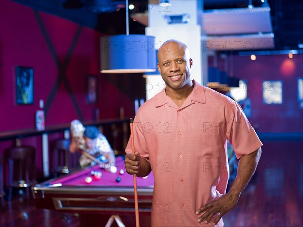 Men enjoying game of pool at bar. Photo : db2stock