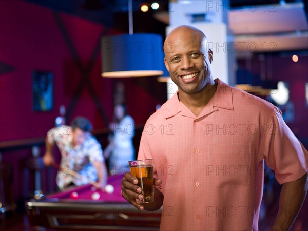 Men enjoying game of pool at bar. Photo : db2stock