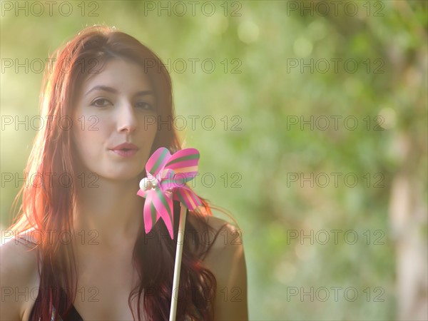 Young woman holding pinwheel. Photo: db2stock