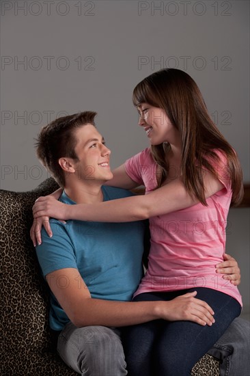 Portrait of teenage boy (16-17) embracing with young woman, studio shot. Photo : Rob Lewine