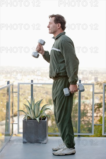 Mature man exercising on balcony. Photo : Rob Lewine