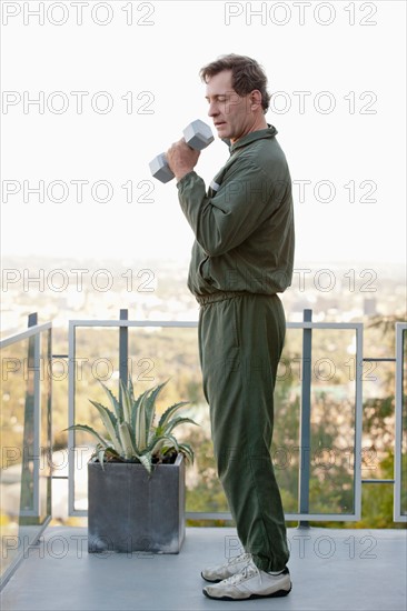 Mature man exercising on balcony. Photo : Rob Lewine