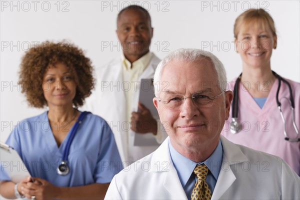 Portrait of four medical professionals, studio shot. Photo : Rob Lewine