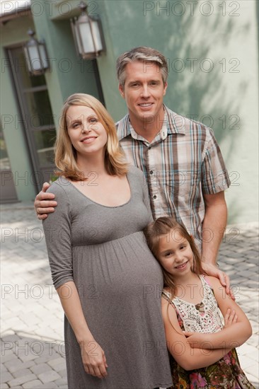 Pregnant mother, father and daughter (6-7) posing for portrait. Photo : Rob Lewine