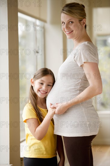 Daughter (6-7) embracing pregnant mother. Photo : Rob Lewine