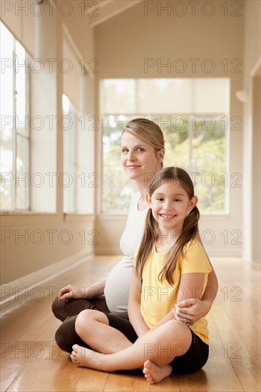 Pregnant mother and daughter (6-7)practicing yoga. Photo: Rob Lewine