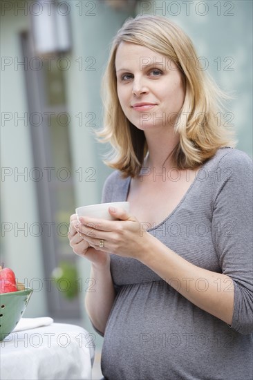 Pregnant woman enjoying cup of tea. Photo : Rob Lewine