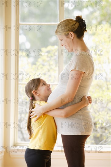 Daughter (6-7) embracing pregnant mother. Photo: Rob Lewine