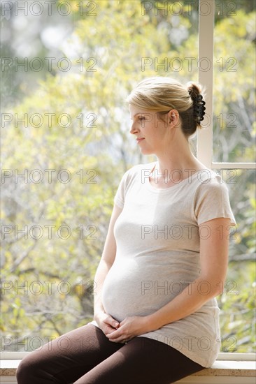 Mid adult pregnant woman sitting on porch. Photo: Rob Lewine