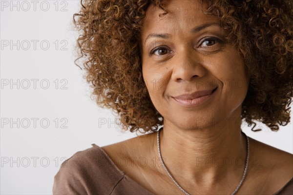 Portrait of mature woman, studio shot. Photo : Rob Lewine