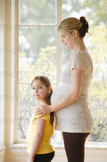 Daughter (6-7) standing next to pregnant mother. Photo : Rob Lewine