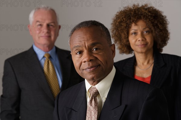 Portrait of three business people, studio shot. Photo : Rob Lewine