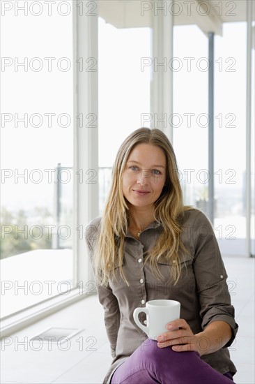 Mature woman relaxing with coffee cup. Photo : Rob Lewine