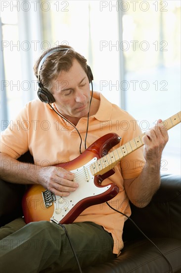 Mature man playing guitar. Photo : Rob Lewine