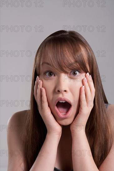 Portrait of young surprised woman, studio shot. Photo : Rob Lewine