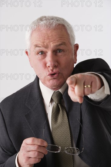 Portrait of senior businessman pointing, studio shot. Photo: Rob Lewine