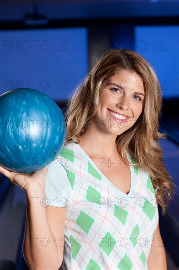 Young smiling woman holding bowling ball. Photo : db2stock