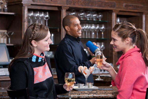 Young women enjoying apres ski drink in bar. Photo : db2stock