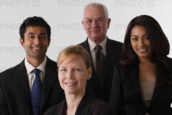 Portrait of four business people, studio shot. Photo : Rob Lewine