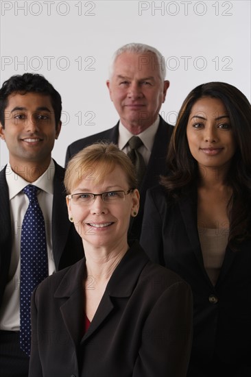 Portrait of four business people, studio shot. Photo : Rob Lewine