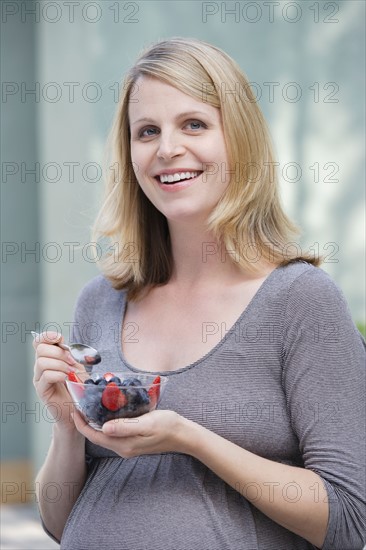 Pregnant woman eating fresh berries. Photo : Rob Lewine